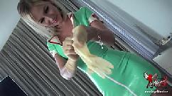 Hot nurse in latex putting on medical gloves